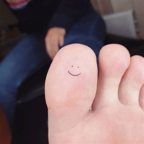 Minimalist smile tattoo on the toe.