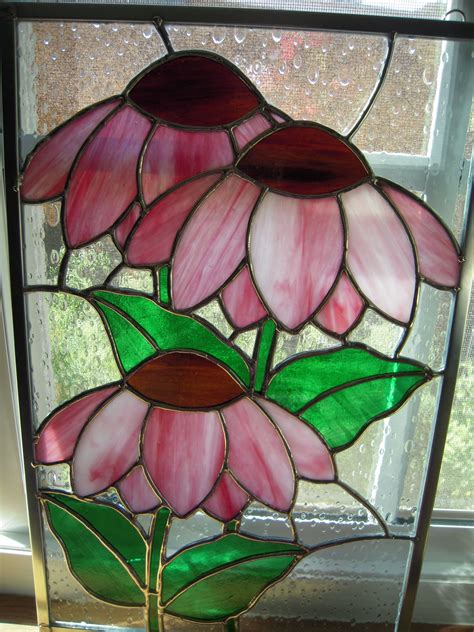 a stained glass window with three pink flowers