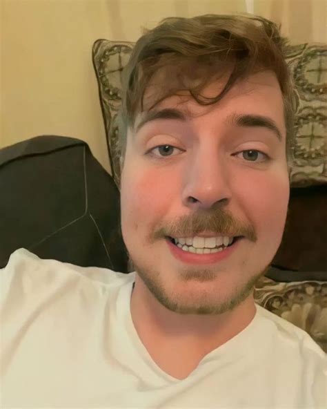 a close up of a person wearing a white t - shirt with a moustache