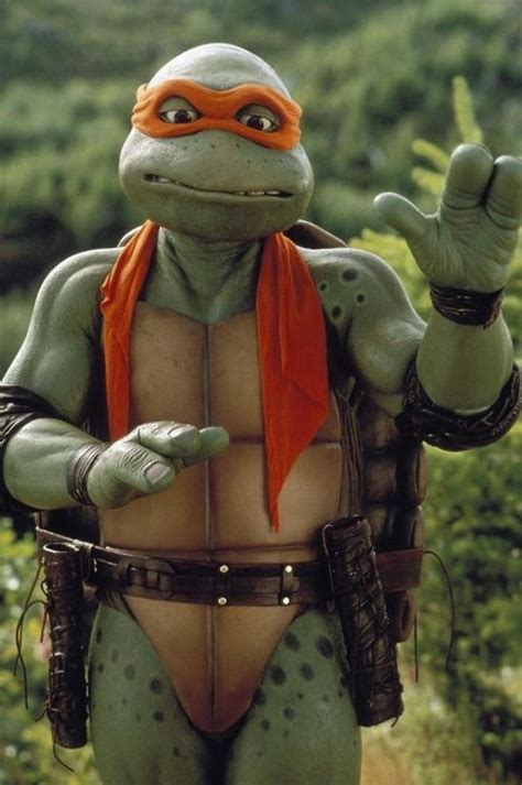 a teenaged tmnt dressed in costume and holding his hands up to the side