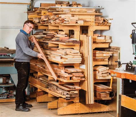 a man standing next to a pile of wood