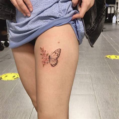 Half butterfly half flowers tattoo placed on the thigh.