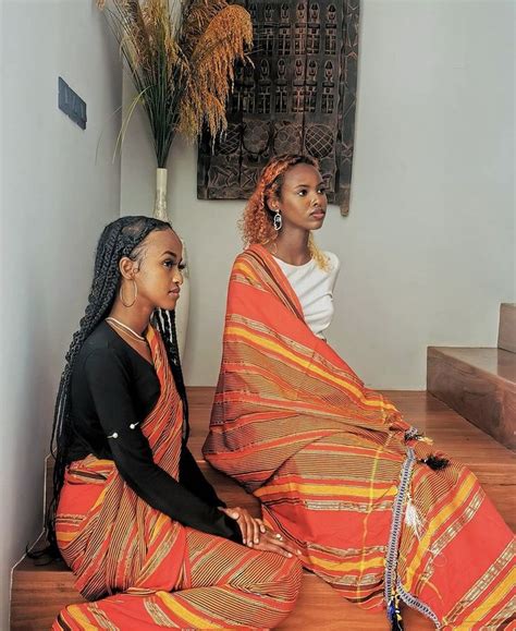 two women sitting on the floor in colorful outfits