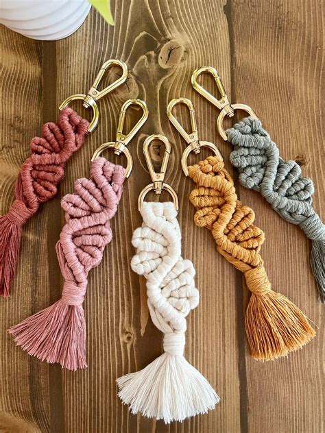 four key chains with tassels on top of a wooden table