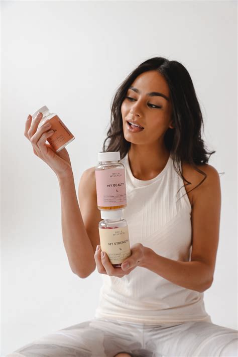 a woman sitting on the floor holding a jar of skin care products in her hand