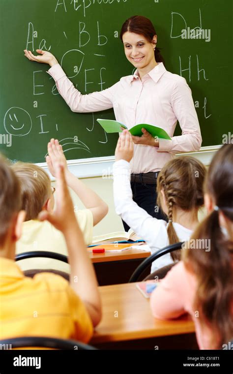 Portrait of smart teacher pointing at blackboard and looking at ...