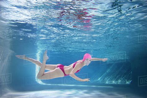 Caucasian woman in bikini swimming underwater - Stock Photo - Dissolve