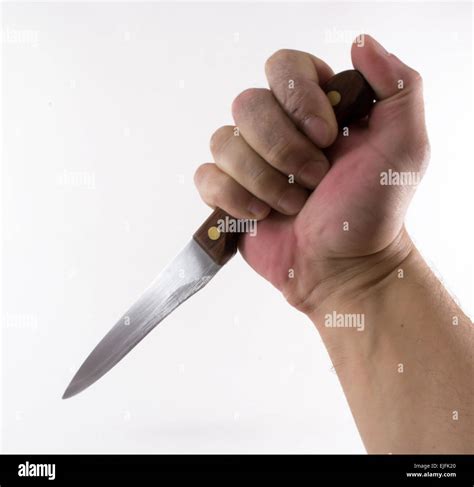 A man's hand holding a knife in a stabbing action Stock Photo - Alamy