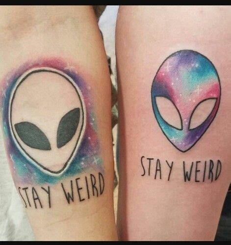 two alien tattoos on both legs that say stay weird and stay weird