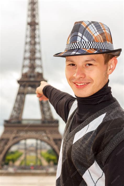 Premium Photo | Young man hipster shows the eiffel tower paris france