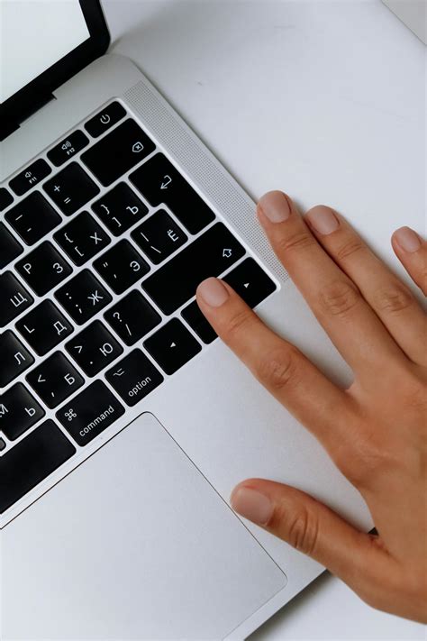 Persons Hand on Macbook Pro · Free Stock Photo