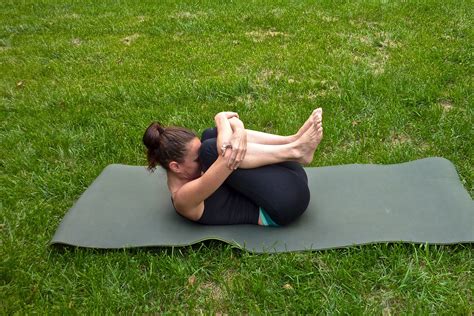 Flexible Woman Doing Knee To Chest Stretch Outside