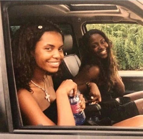 two women are sitting in the back seat of a car and one is holding a ...