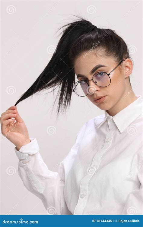 Beautiful Caucasian Hipster Girl with Black Hair and Glasses is Posing in Studio on Isolated ...