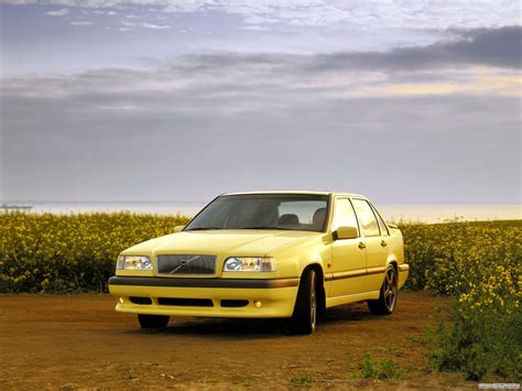 a yellow car is parked in the middle of a dirt road next to some flowers