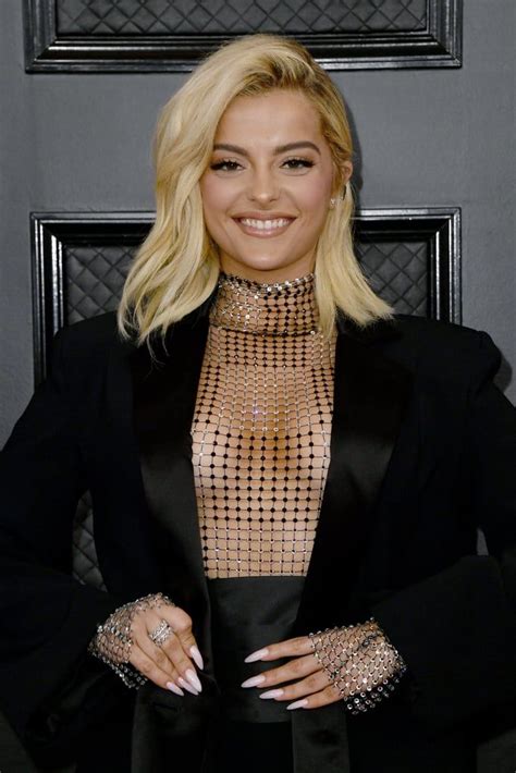 the singer poses in front of a black wall wearing an elaborate outfit and diamond jewelry