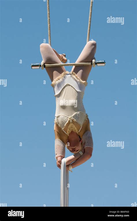 Female trapeze artist hangs from swing Stock Photo - Alamy