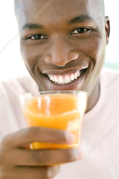 Man drinking orange juice - Stock Image - F001/2490 - Science Photo Library