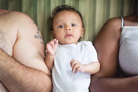 "Biracial Baby Lying In Bed Between Her Black Mother And White Father" by Stocksy Contributor ...