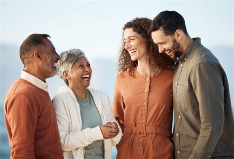 Premium Photo | Happy family parents and couple laughing at the beach ...