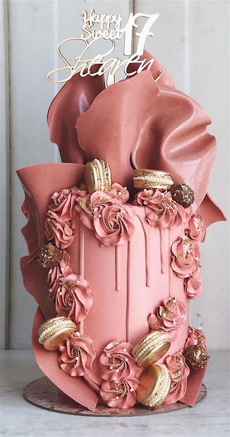 a pink cake with gold decorations on top