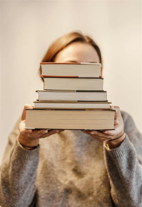 Unrecognizable female student showing heap of textbooks · Free Stock Photo