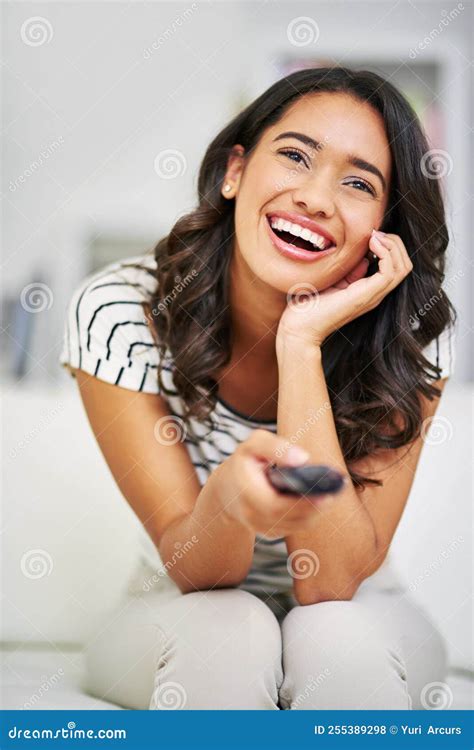 Shes Loving This Show. A Young Woman Watching TV While Relaxing On Her Sofa At Home. Stock Photo ...