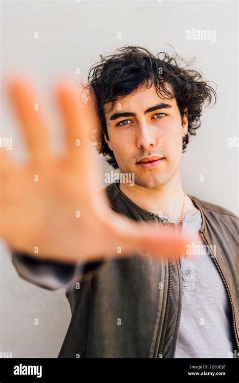 Young man stretching hand in front of wall Stock Photo - Alamy