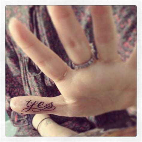 Tattoo of the word "yes" located on the thumb.