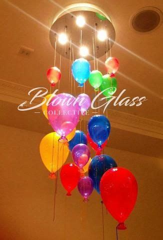 a chandelier made out of balloons hanging from the ceiling with lights ...