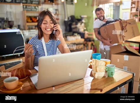 Happy young girl working at a coffee shop with a laptop Stock Photo - Alamy