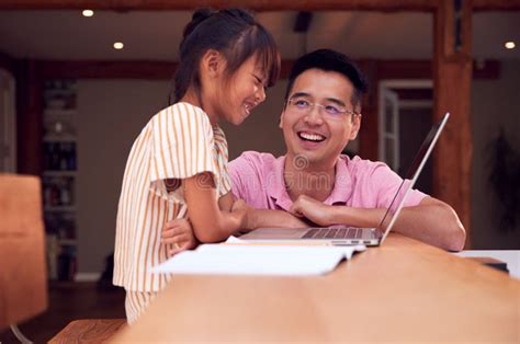 Asian Father Helping Home Schooling Daughter Working at Table in Kitchen on Laptop Stock Photo ...