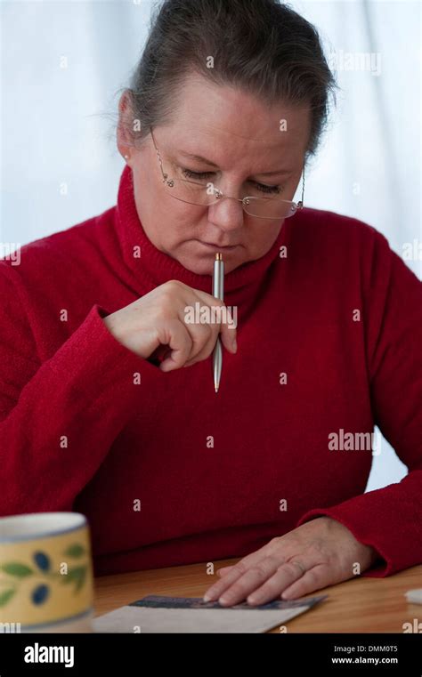 Woman at dining room table writing letters Stock Photo - Alamy