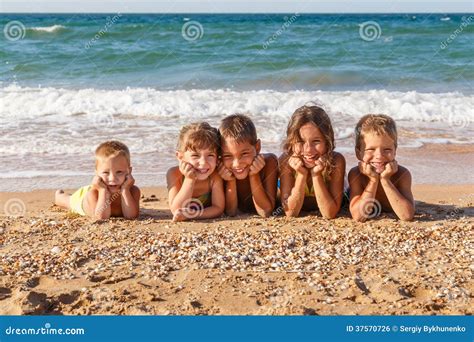 Five kids on the beach stock photo. Image of enjoying - 37570726