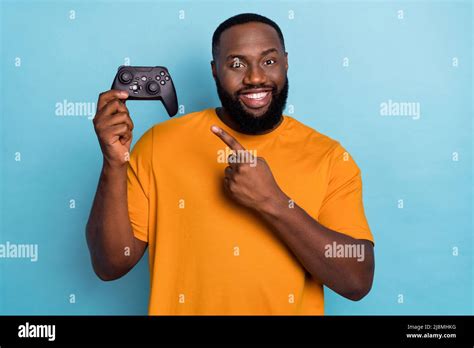 Portrait of handsome trendy cheerful guy playing game demonstrating ...