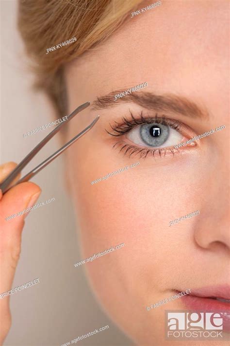 Beautiful woman plucking eyebrow with tweezers, Stock Photo, Picture ...