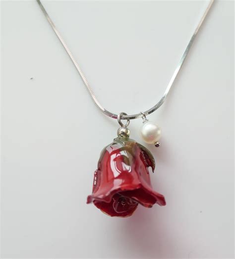 Rose bud and Akoya pearl necklace. Made with a resin coated rose bud, this delicate pendant is ...