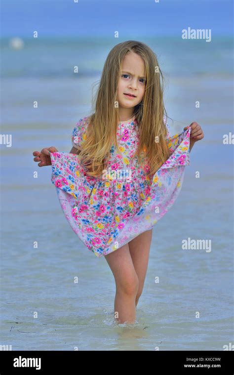 Cute little girl on sandy beach . Blue ocean and sky background. Cuba. Caya Coco Stock Photo - Alamy