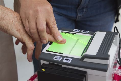 Man guiding another in using a fingerprint scanner - American DataBank