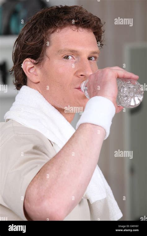 Man drinking from water bottle in gym Stock Photo - Alamy