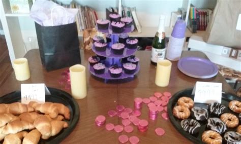 a table topped with two black plates filled with donuts and cupcakes next to each other