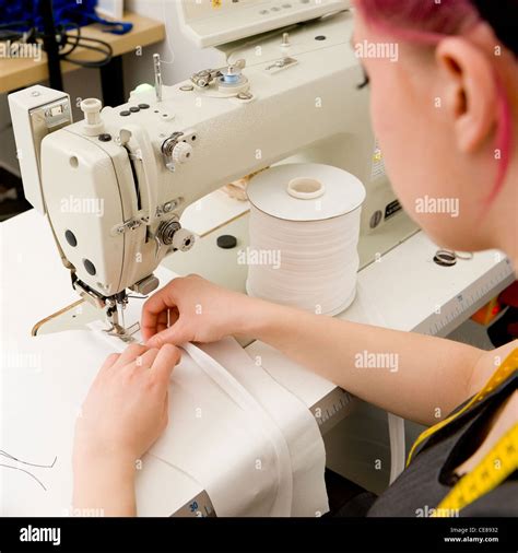 Dressmaker with sewing machine in her studio Stock Photo - Alamy