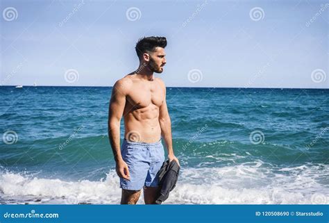 Young Man Standing on a Beach Alone and Lonely Stock Photo - Image of hand, shorts: 120508690