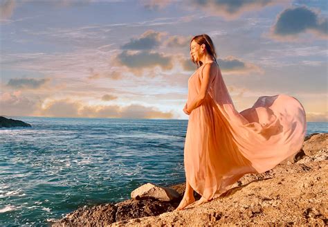 Sydne Style shows pretty beach pregnancy announcement photos in flowy dress in hawaii | Sydne Style