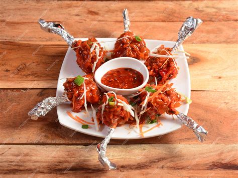 Premium Photo | Chicken lollipop schezwan is an Indian Chinese appetizer served over a wooden ...