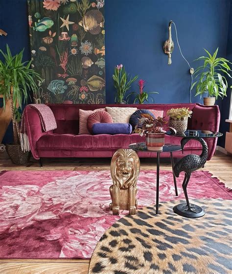 a living room with blue walls and pink couches, rugs and plants on the wall