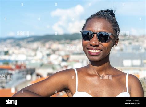 Woman wearing sunglasses on a hot day. Blurred city view background ...