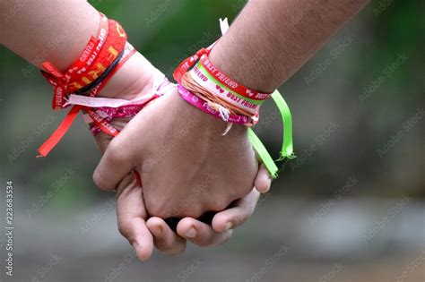 Best friends holding hands wearing friendship bands/Happy friendship day Stock Photo | Adobe Stock