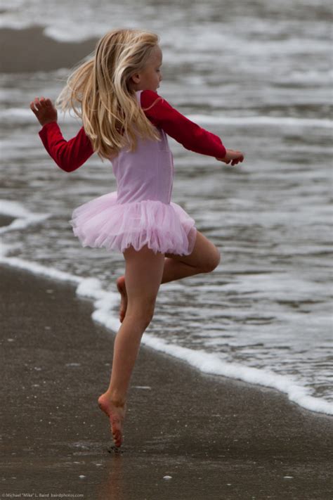 Cute Little Girl in Pink Dances on Beach during the Kite... - Shunamity