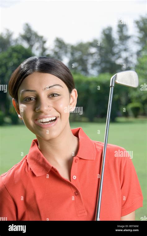 Woman with a golf club in a golf course Stock Photo - Alamy